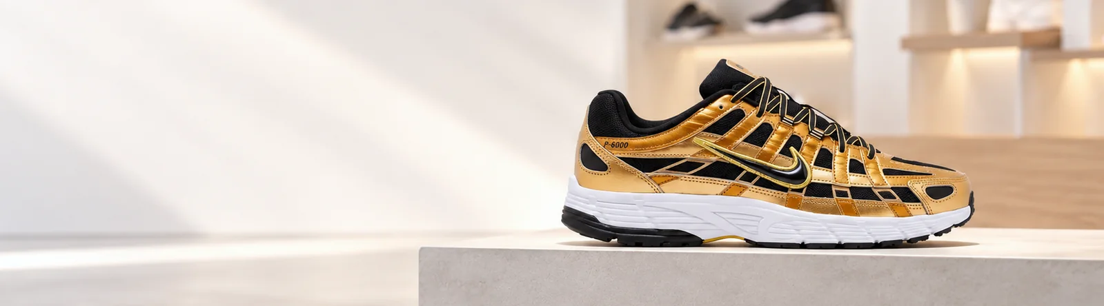 Zapatilla Nike P-6000 dorada sobre un bloque de concreto en una tienda